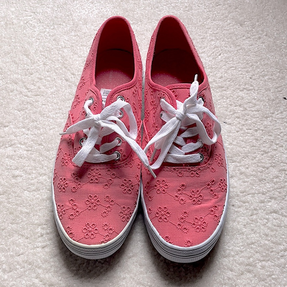 Coral pink shoes with embroidered flowers.